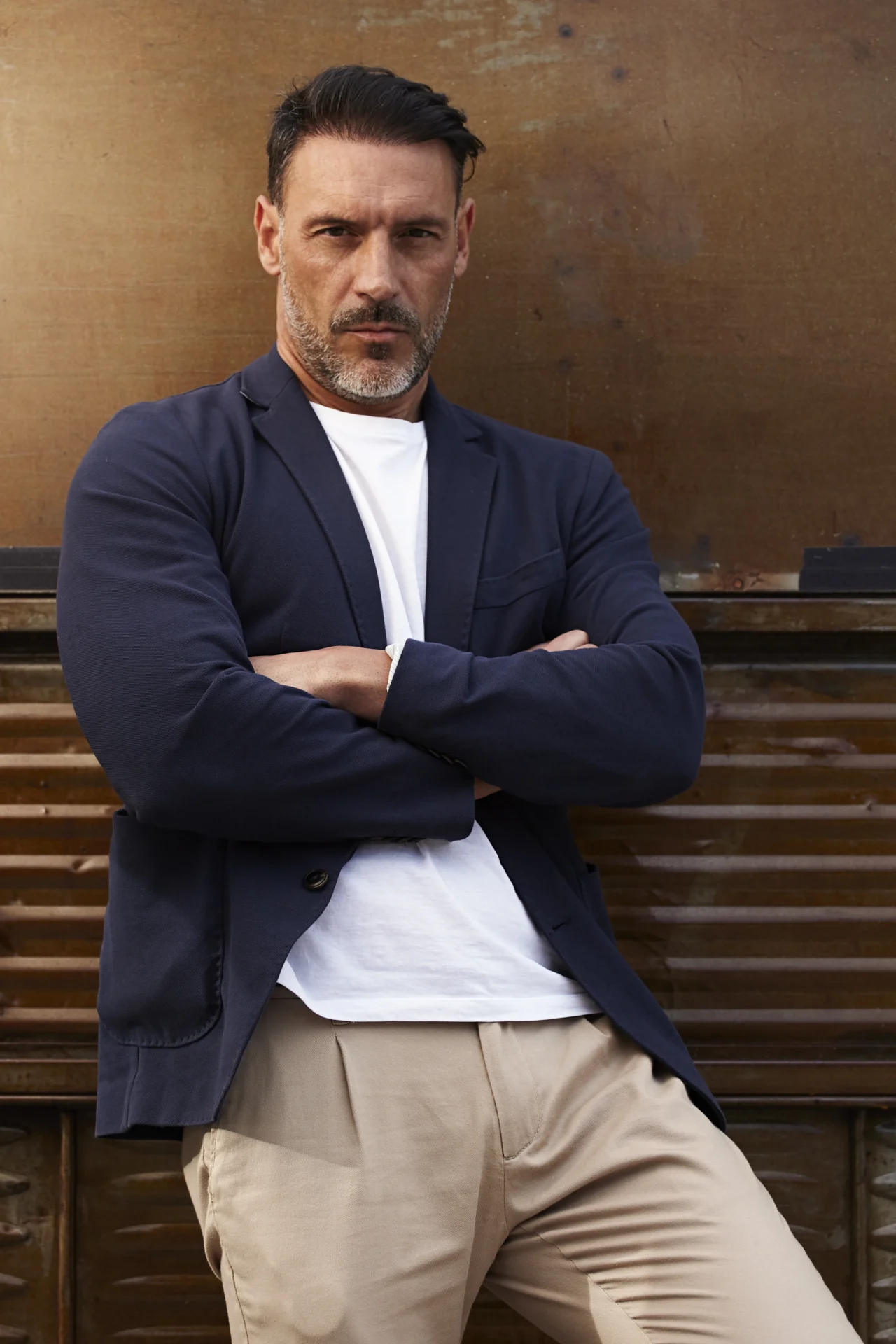 middle-aged-man-wearing-leaning-against-rusty-colored-background middle aged man wearing leaning against rusty colored background scaled