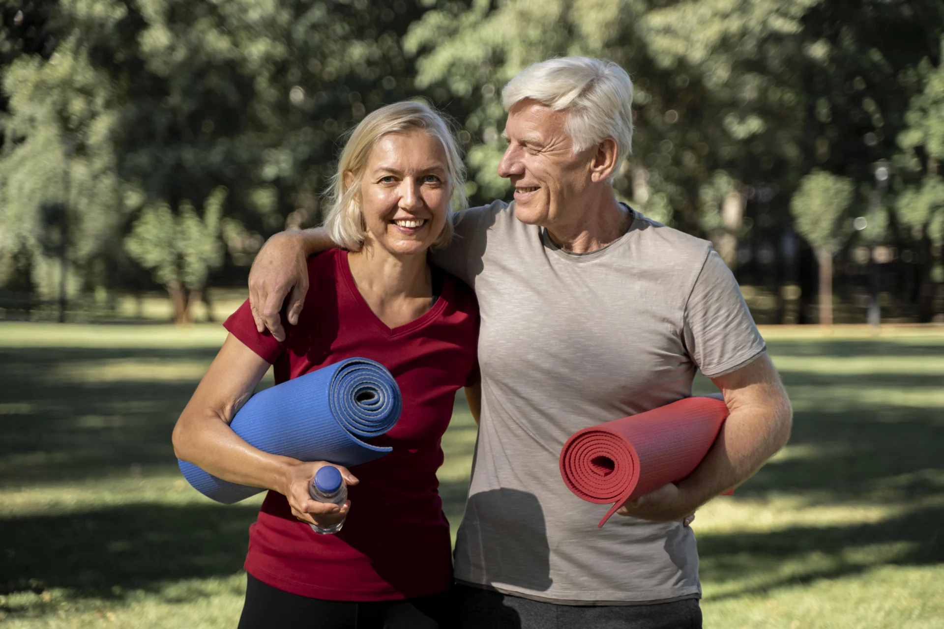 smiley-elder-couple-outdoors-with-yoga-mats-water-bottle smiley elder couple outdoors with yoga mats water bottle scaled